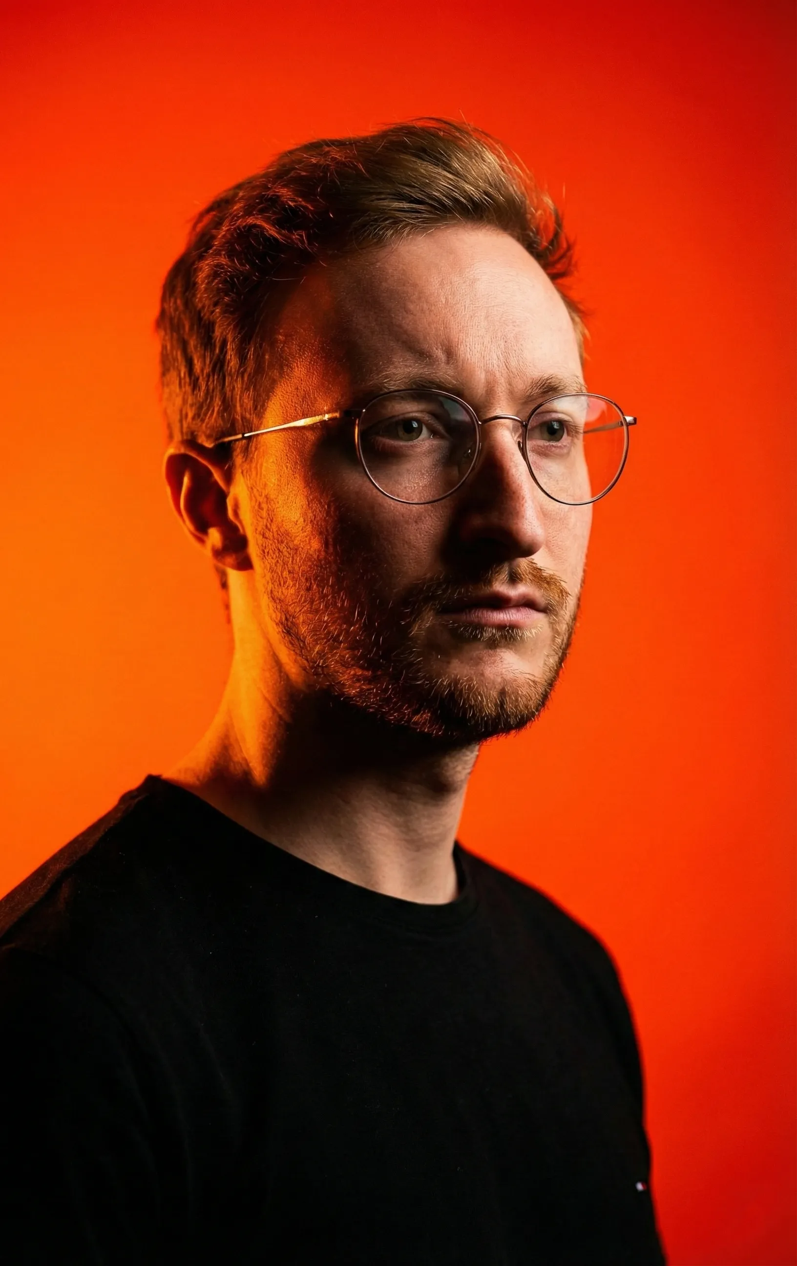 Porträt von Gordon Zimmermann, Senior Motion Designer aus Potsdam, vor orangefarbenem Hintergrund