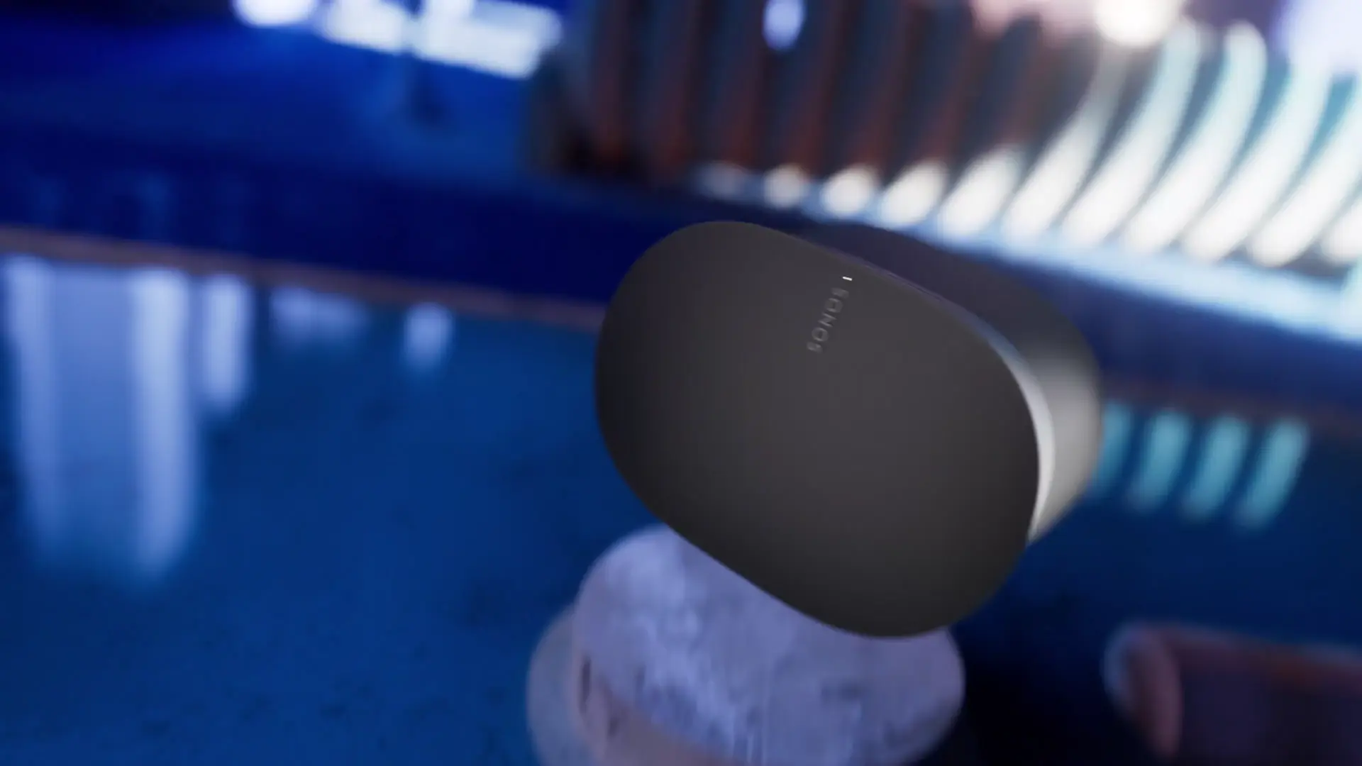Sonos-Era-Lautsprecher schwebend über einem Stein in einer blau ausgeleuchteten Szene